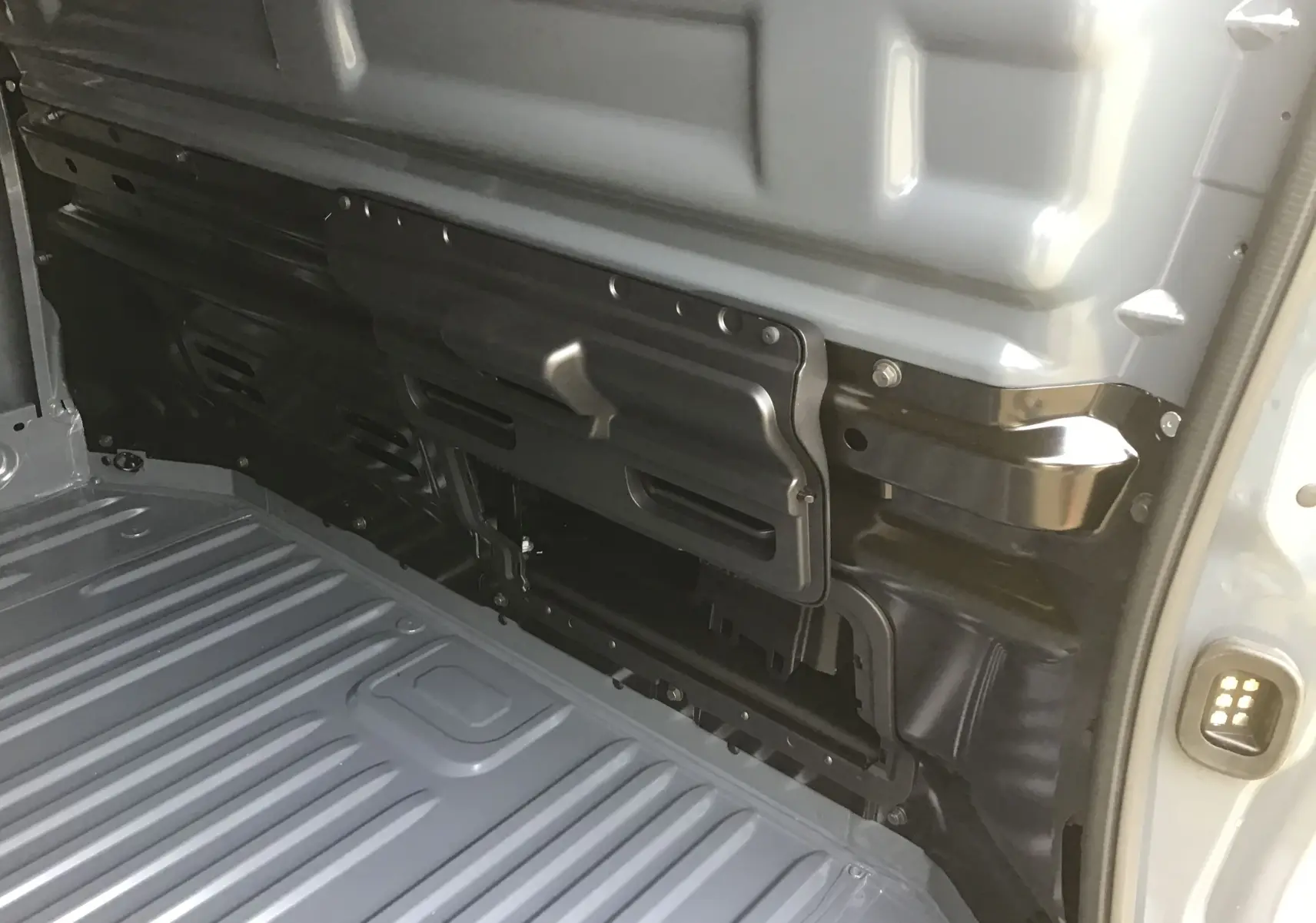 Vue intérieure du compartiment de chargement gris urbain du Renault Trafic Fourgon L2H1 avec cloison séparatrice partielle.