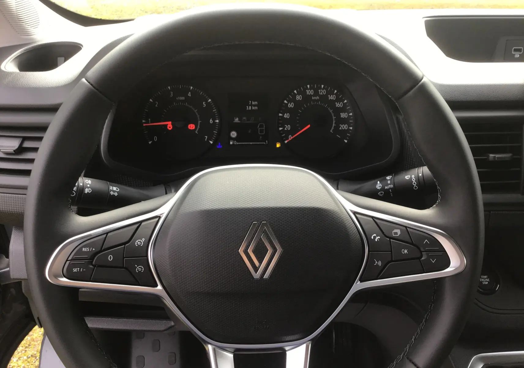 Vue rapprochée du volant noir du Renault Trafic Fourgon 2025 avec commandes intégrées et tableau de bord digital.