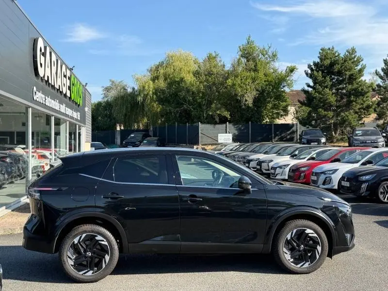 Vue de profil côté gauche d’un Nissan Qashqai 2025 noir Kuro métallisé, avec jantes alu et lignes modernes.