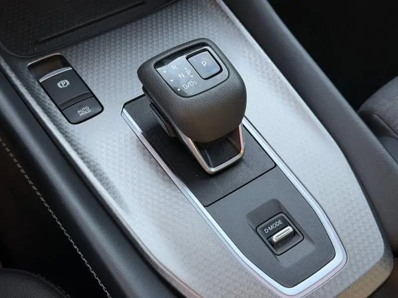 Gros plan sur le levier de vitesses automatique et la commande D-MODE du Nissan Qashqai 2025, intérieur noir et argenté.