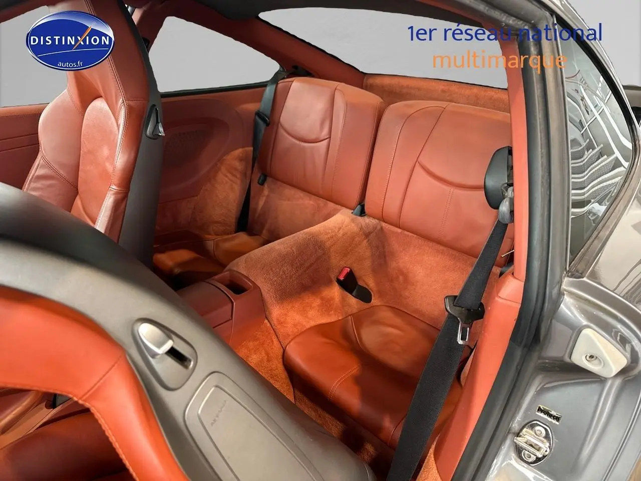 Vue intérieure arrière droite de la Porsche 911 (997) carrera pdk 2009 avec sellerie cuir marron et moquette assortie.