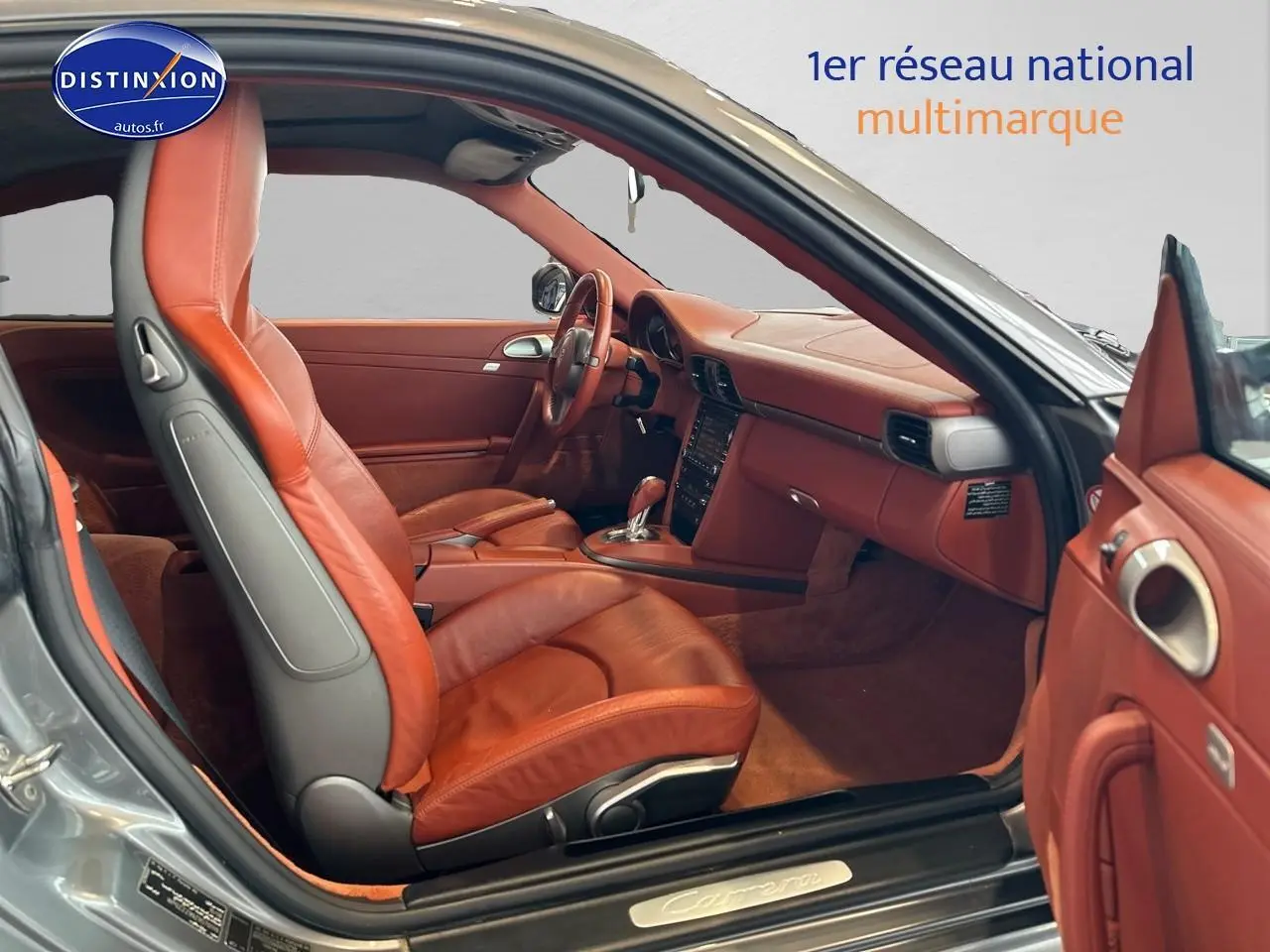 Intérieur cuir marron vu côté conducteur d'une Porsche 911 (997) Carrera PDK gris, avec tableau de bord et sièges sport visibles.