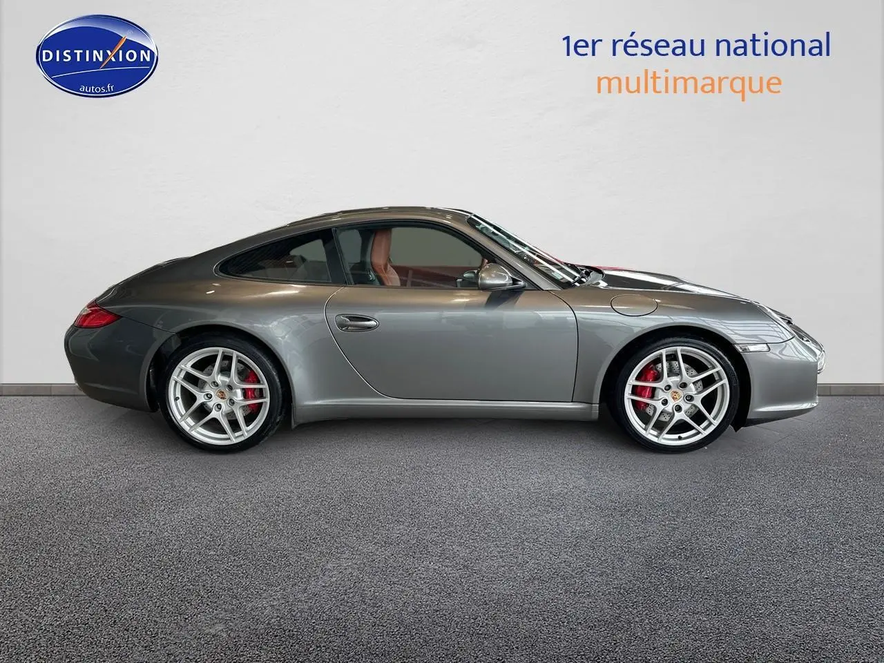 Profil latéral droit d'une Porsche 911 (997) Carrera PDK gris métallisé avec jantes alu et intérieur cuir marron.