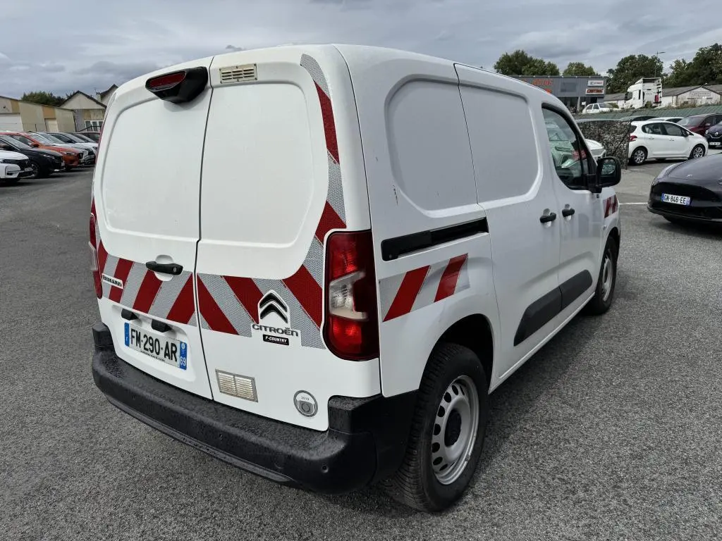 Vue 3/4 arrière droite du Citroën Berlingo blanc avec bandes réfléchissantes rouges et pare-chocs noirs.