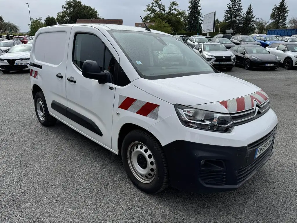 Fourgon Citroën Berlingo blanc en 3/4 avant droit avec bandes réfléchissantes rouges et blanches sur capot et ailes.