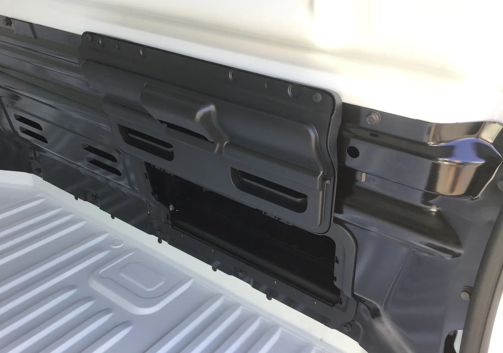 Détail du compartiment de cloison séparatrice noir dans l’espace de chargement blanc du Renault Trafic Fourgon L2H1.