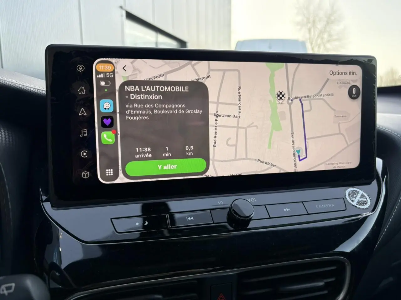 Écran tactile central du Nissan Juke 2024 affichant un itinéraire avec interface Apple CarPlay en intérieur noir brillant.