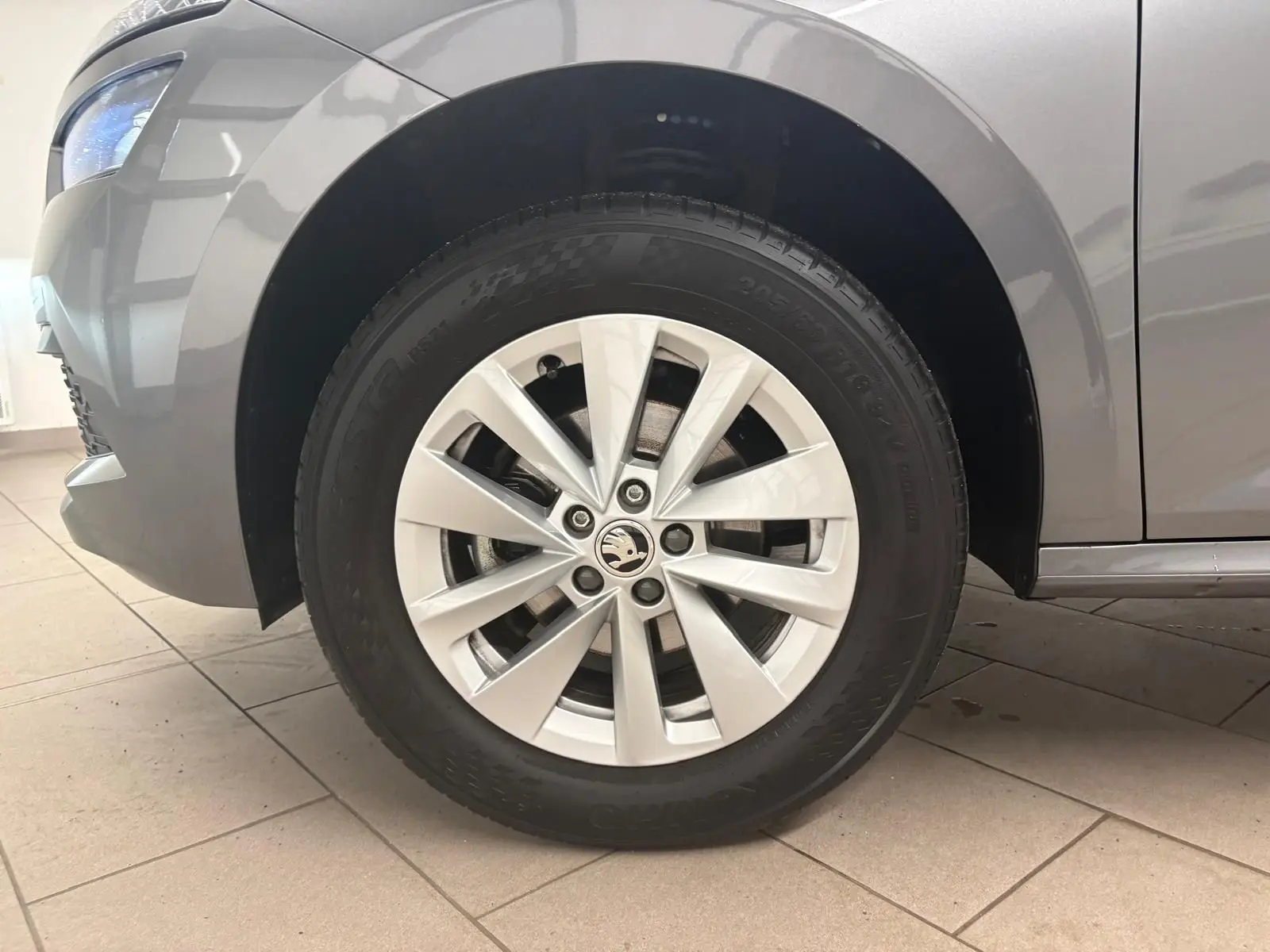 Gros plan sur la roue avant gauche d’un Skoda Kamiq 2023 gris graphite avec jante alliage à dix branches.