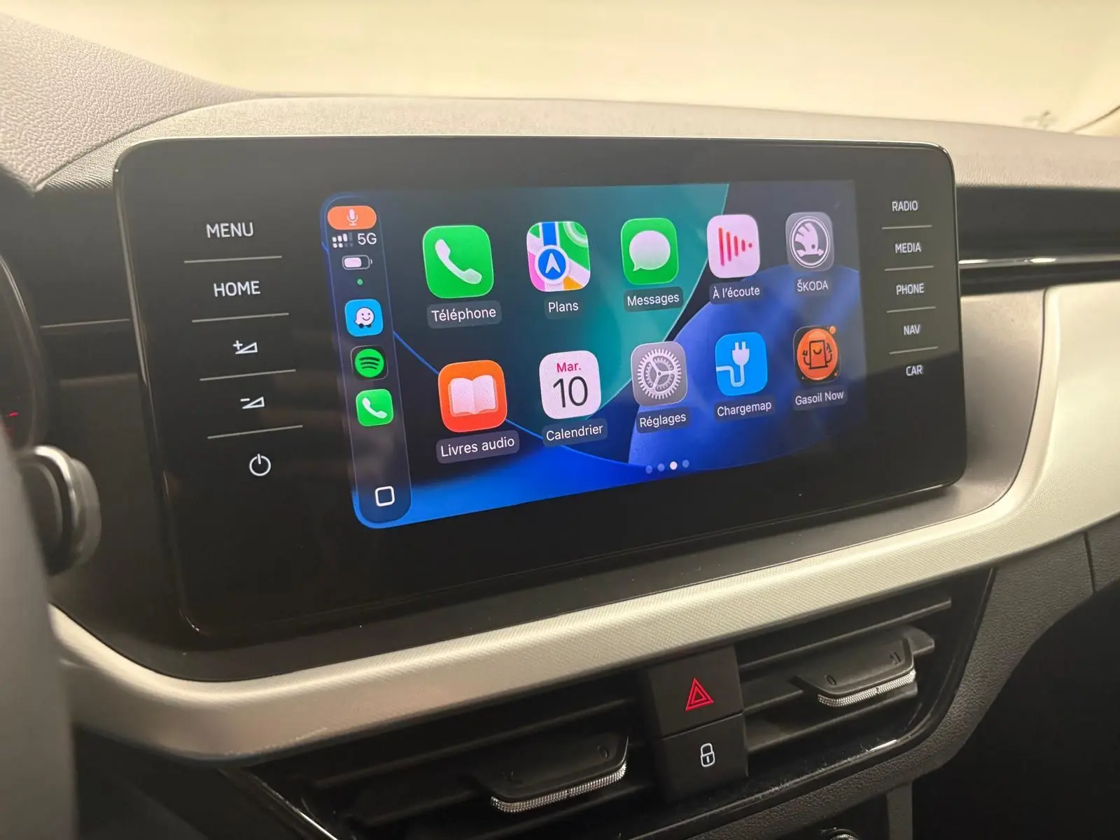 Écran tactile central du Skoda Kamiq 2023 affichant les applications connectées, avec commandes latérales visibles.