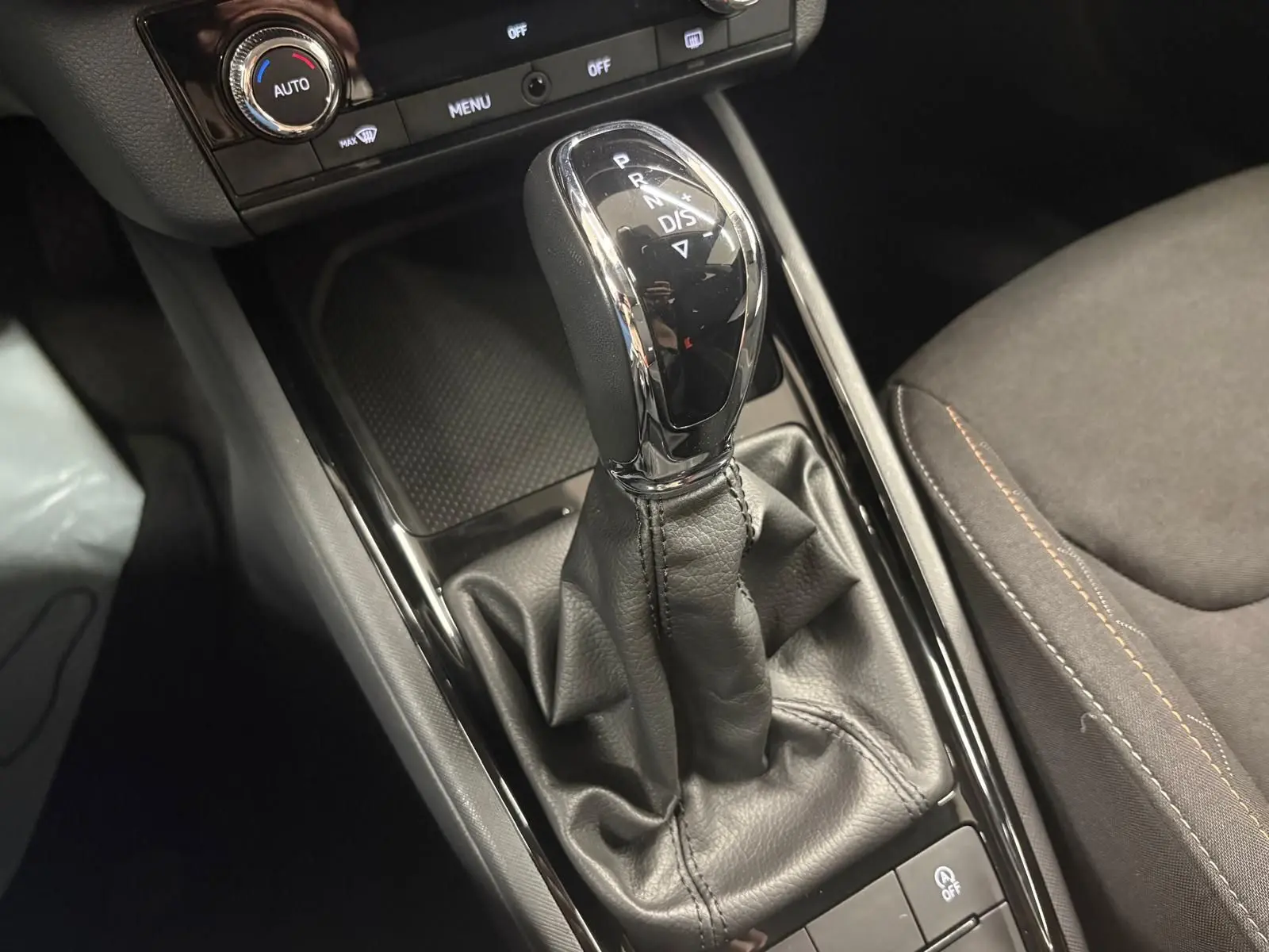 Gros plan sur le levier de vitesses automatique du Skoda Kamiq 2023, finition Business, avec sellerie noire et coutures contrastées.
