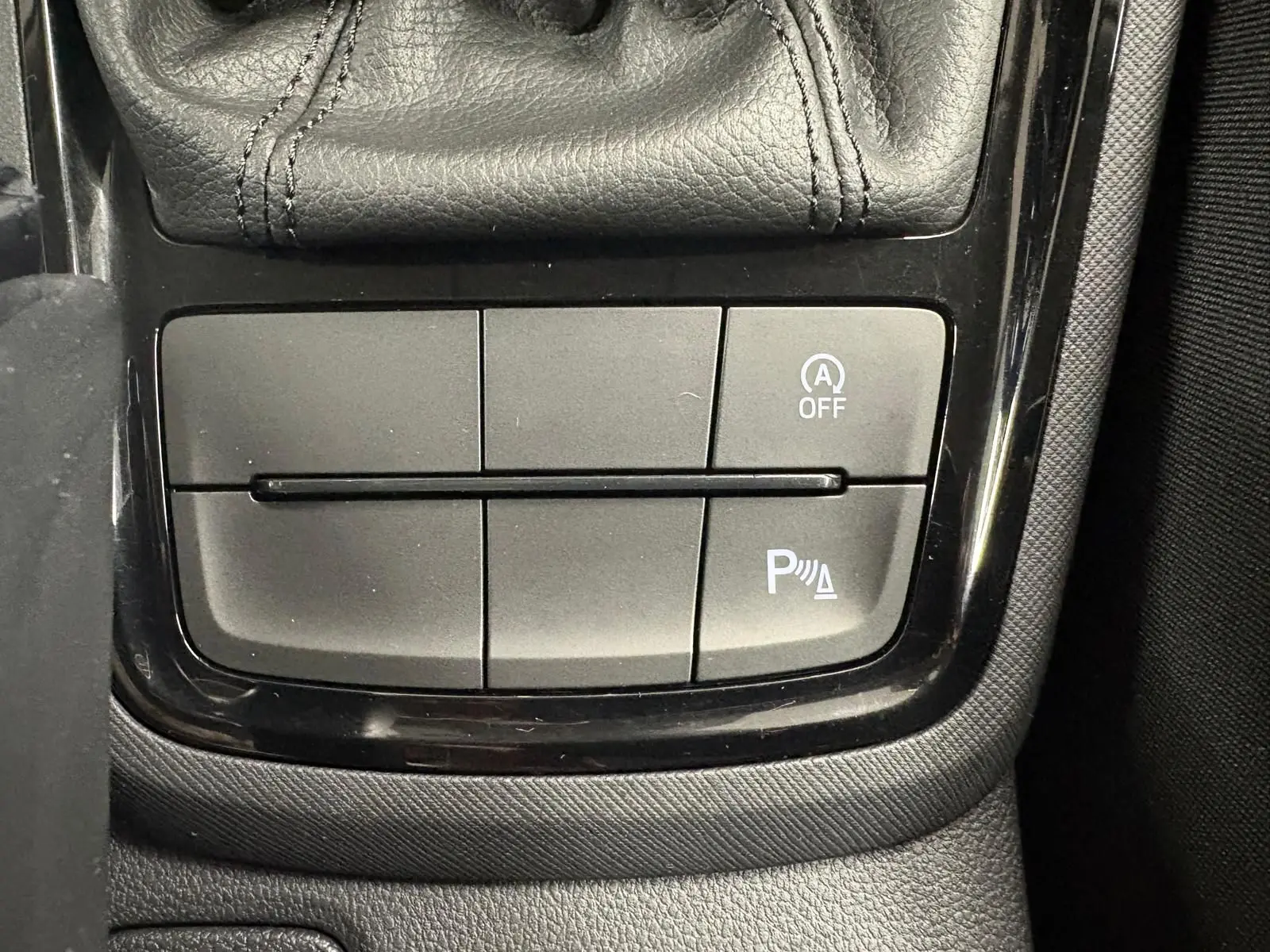 Gros plan sur les commandes près du levier de vitesse d’un Skoda Kamiq 2023, finition Business, intérieur noir.