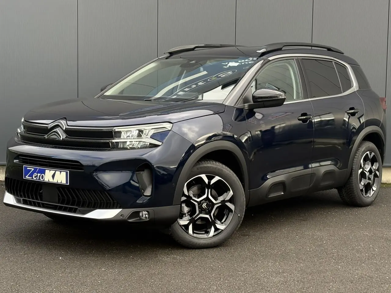 Citroën C5 Aircross Bleu Eclipse en 3/4 avant droit avec jantes diamantées et barres de toit noires.