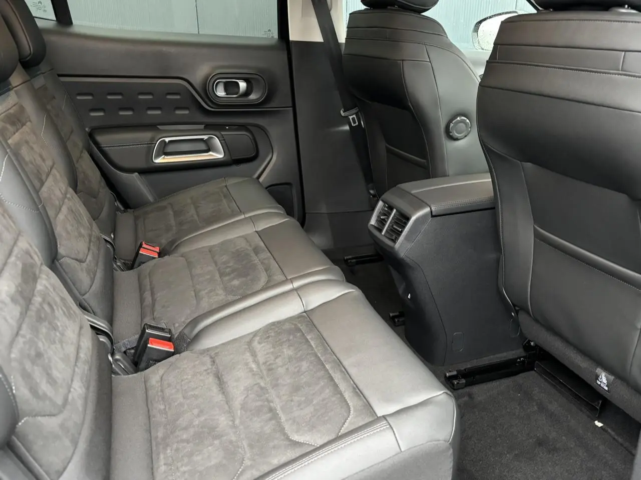 Vue intérieure arrière du Citroën C5 Aircross 2025 avec sièges Alcantara noir Urban Black et accoudoir central.