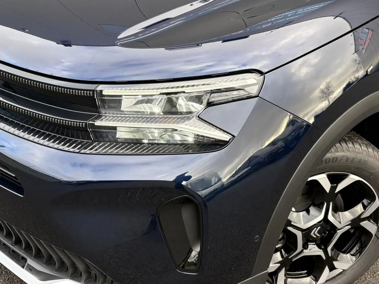 Gros plan sur l'avant droit bleu Eclipse du Citroën C5 Aircross 2025, avec phares LED et jante alliage 18'' bi-ton.
