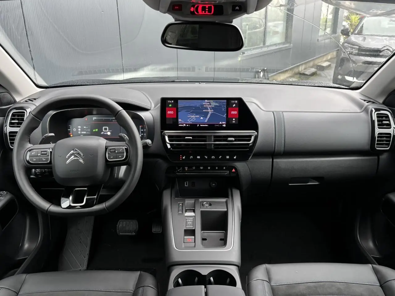 Vue intérieure avant du Citroën C5 Aircross 2025, tableau de bord noir avec écran tactile et volant multifonction.
