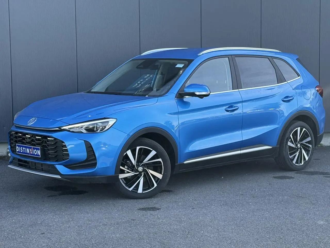 MG Motor ZS 1.5 Hybrid+ 197 Luxury bleu Como en 3/4 avant droit avec jantes alliage 18 pouces et rails de toit.