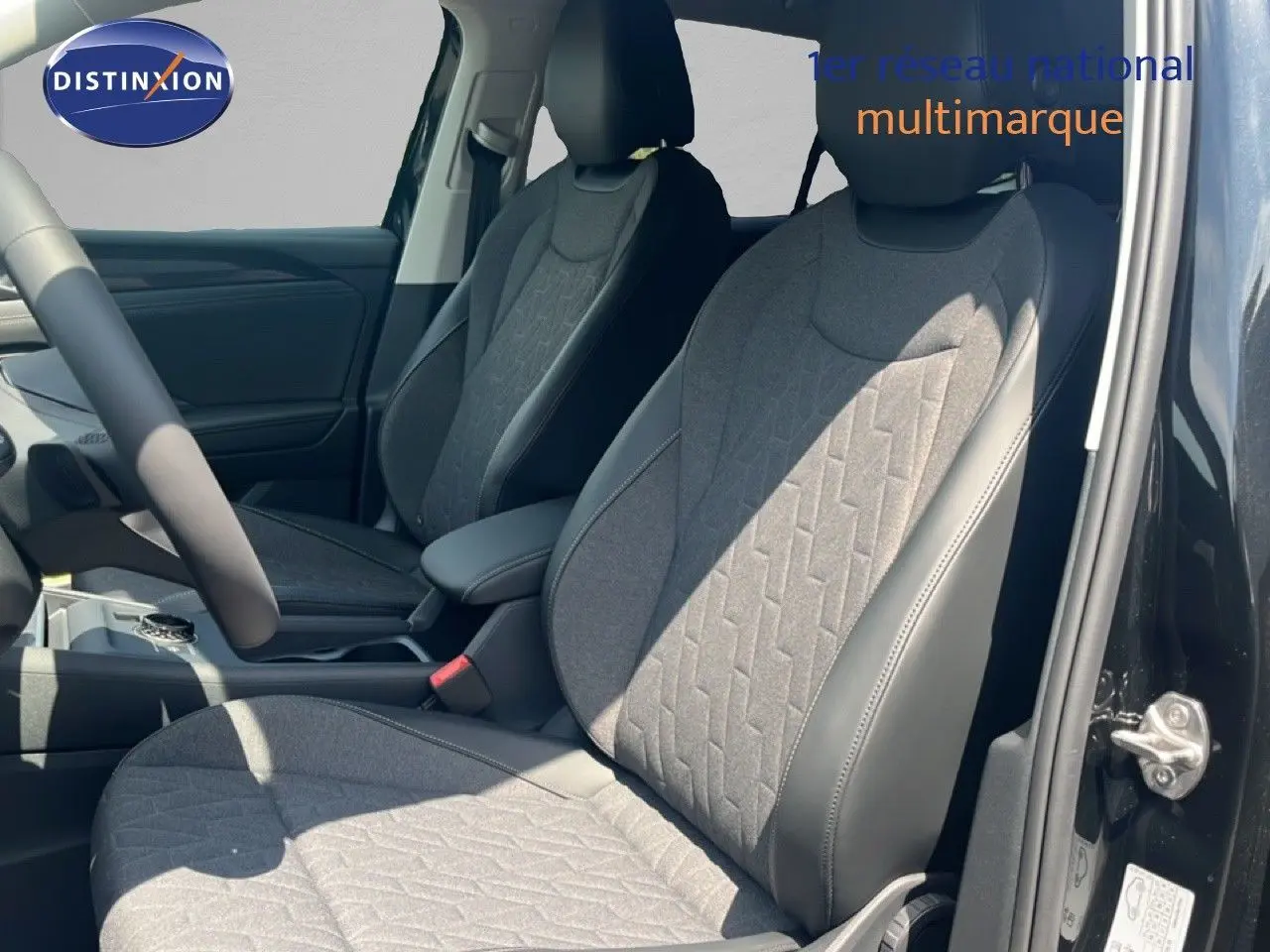 Vue intérieure côté droit des sièges avant en tissu gris et cuir noir du Volkswagen Tiguan noir Grenadilla 2026.