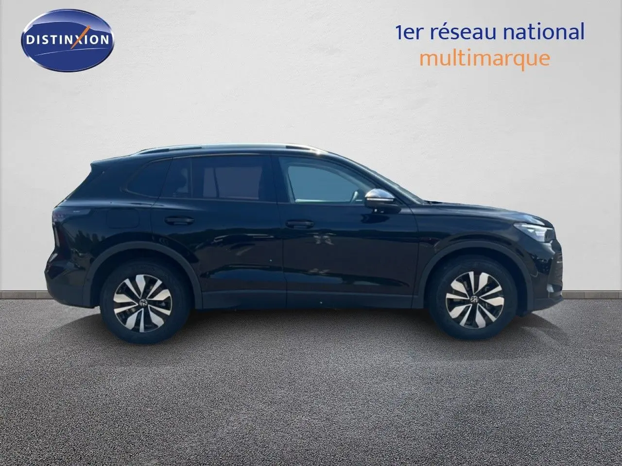 Volkswagen Tiguan noir grenadilla métal vu de profil côté gauche, avec jantes distinctives et toit ouvrant.