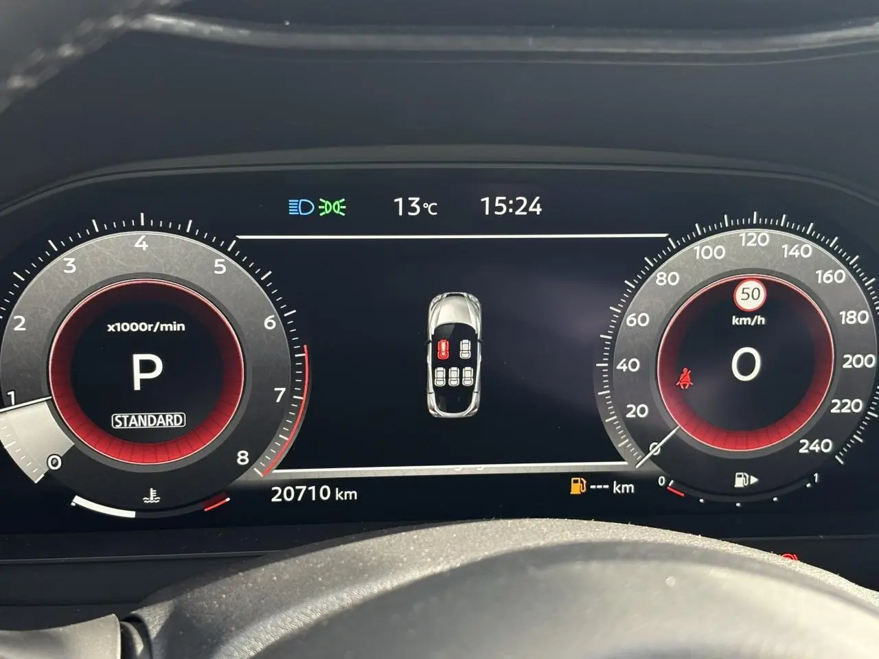 Tableau de bord numérique du Nissan Juke 2025 affichant la vitesse, régime moteur et alertes, vue frontale rapprochée.