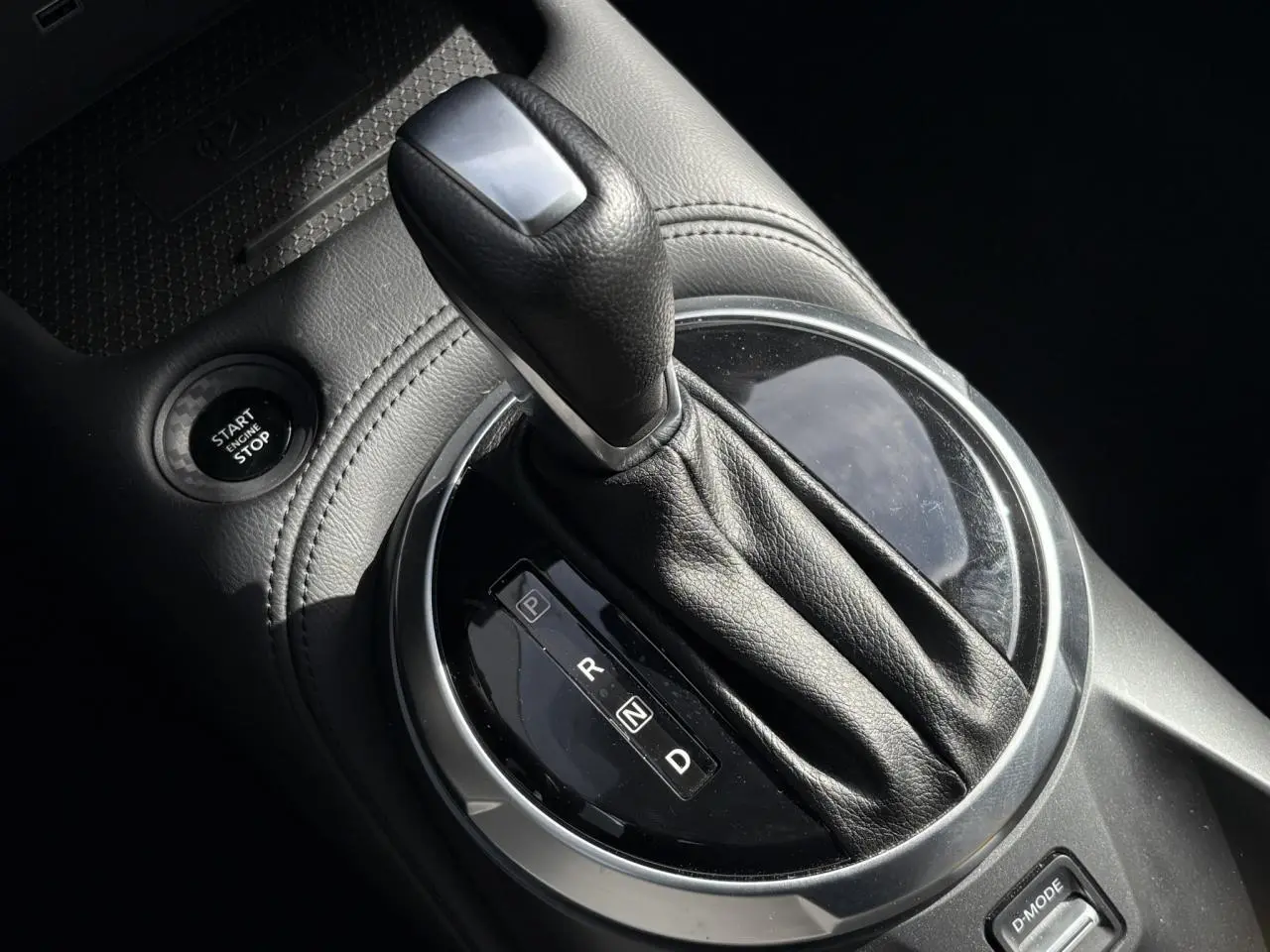 Gros plan sur le levier de vitesses automatique noir et argenté du Nissan Juke 2025, avec bouton Start/Stop visible.