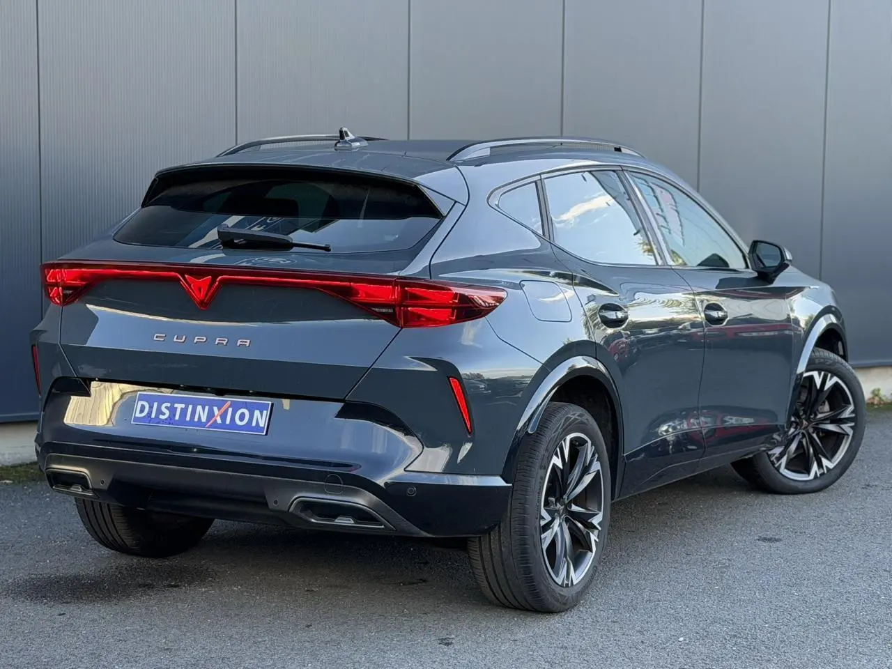 Vue 3/4 arrière droite d'une CUPRA Formentor bleu Fjord avec signature lumineuse Tri-LED et jantes alliage 18 pouces.