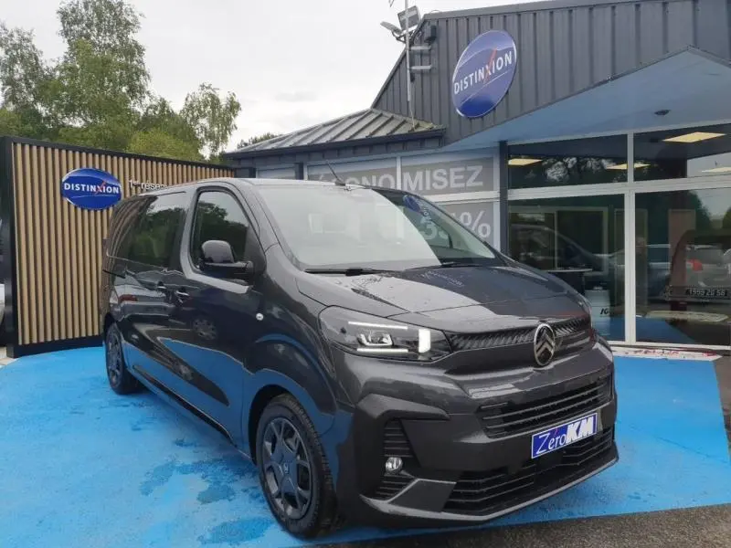 Véhicule utilitaire Citroën Jumpy gris titane métal en vue 3/4 avant droit, stationné devant un showroom Distinxion.