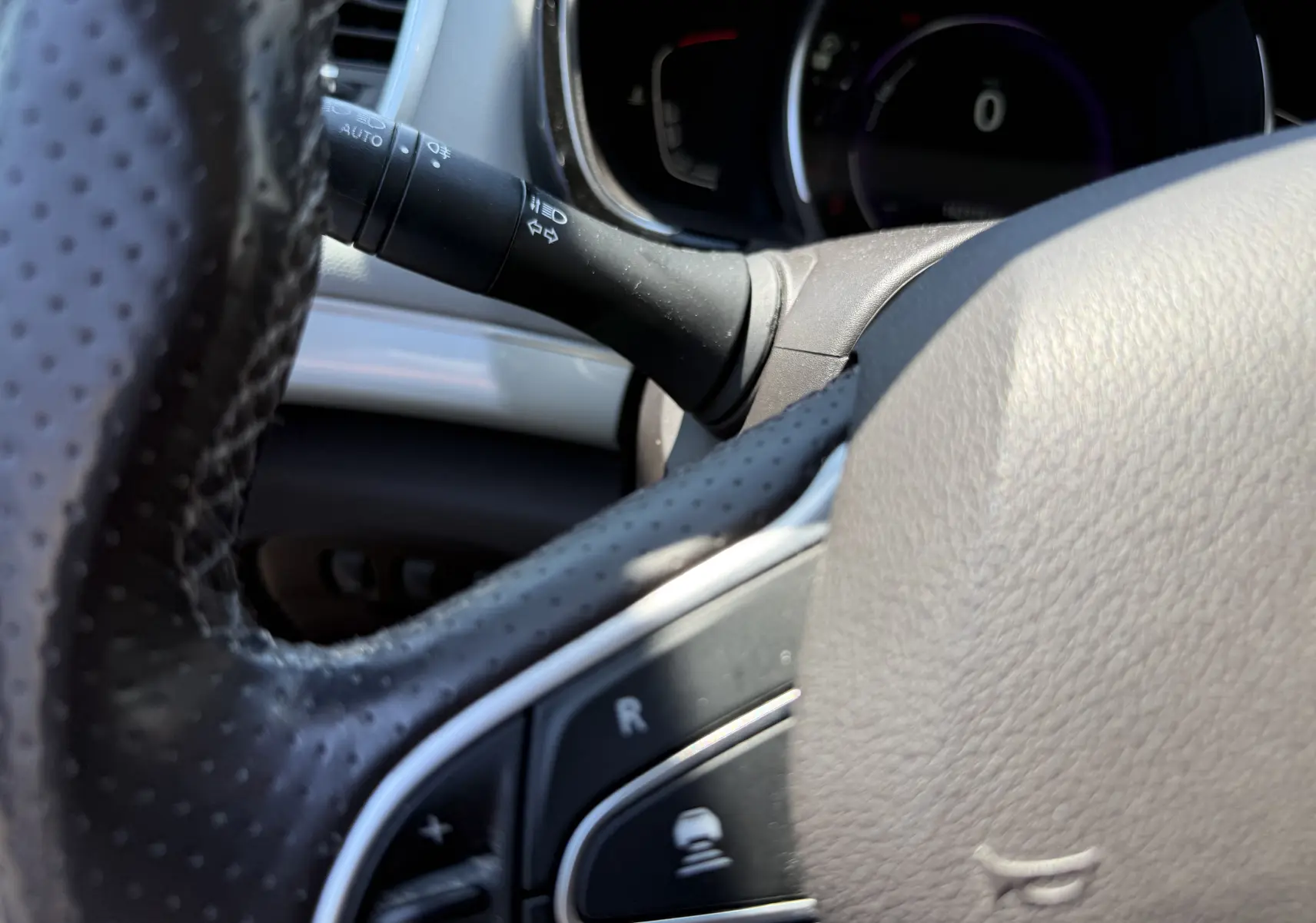 Gros plan sur le volant noir perforé et la commande de clignotant du Renault Espace V 2017, version Initiale Paris.