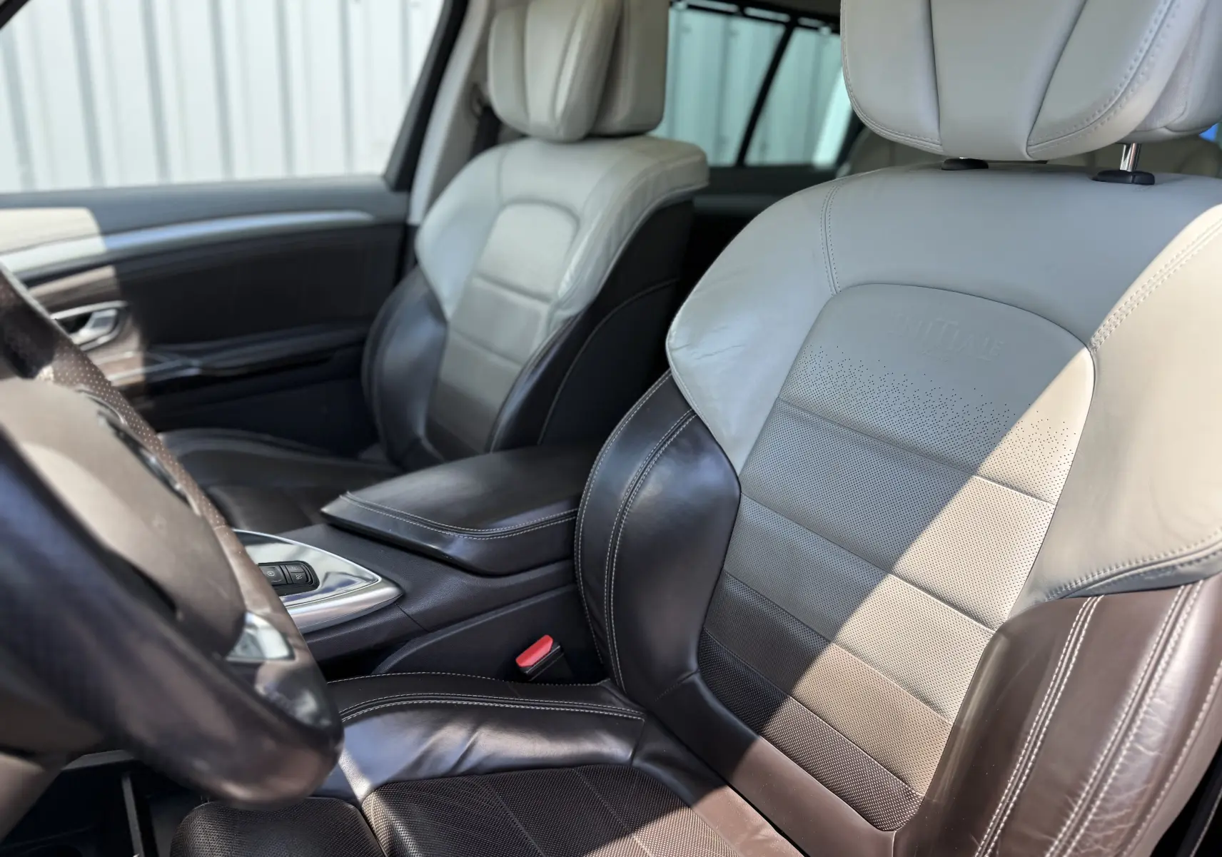 Vue rapprochée des sièges avant en cuir bicolore beige et marron du Renault Espace V Initiale Paris, côté gauche intérieur.