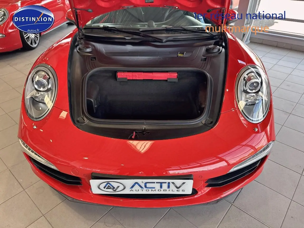 Vue de face rapprochée d'une Porsche 911 (991) Carrera 4 PDK rouge avec capot avant ouvert montrant le coffre.