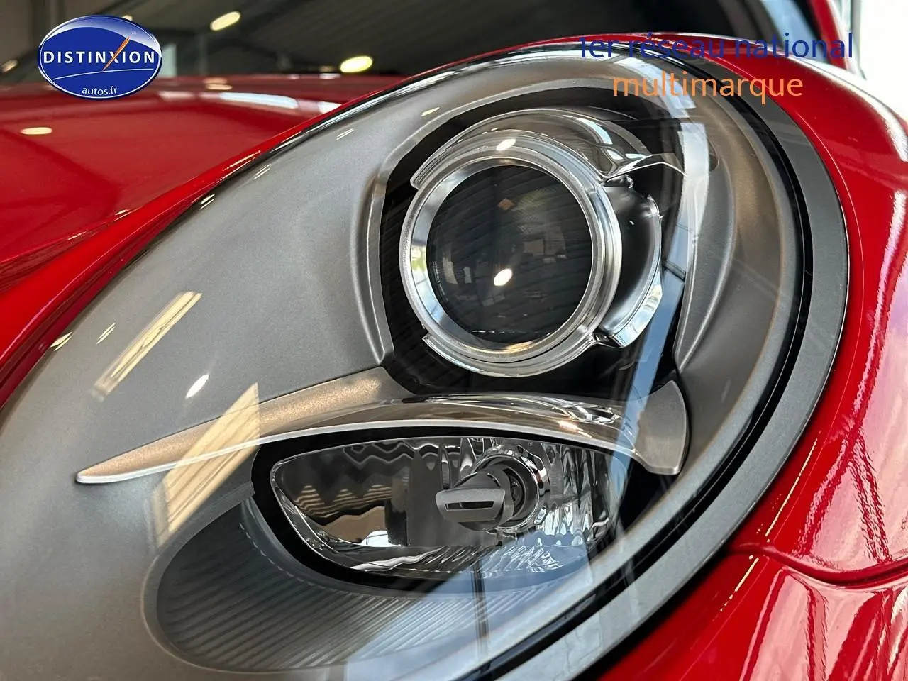 Gros plan sur le phare avant droit argenté et rouge vif d'une Porsche 911 (991) Carrera 4 PDK de 2013.