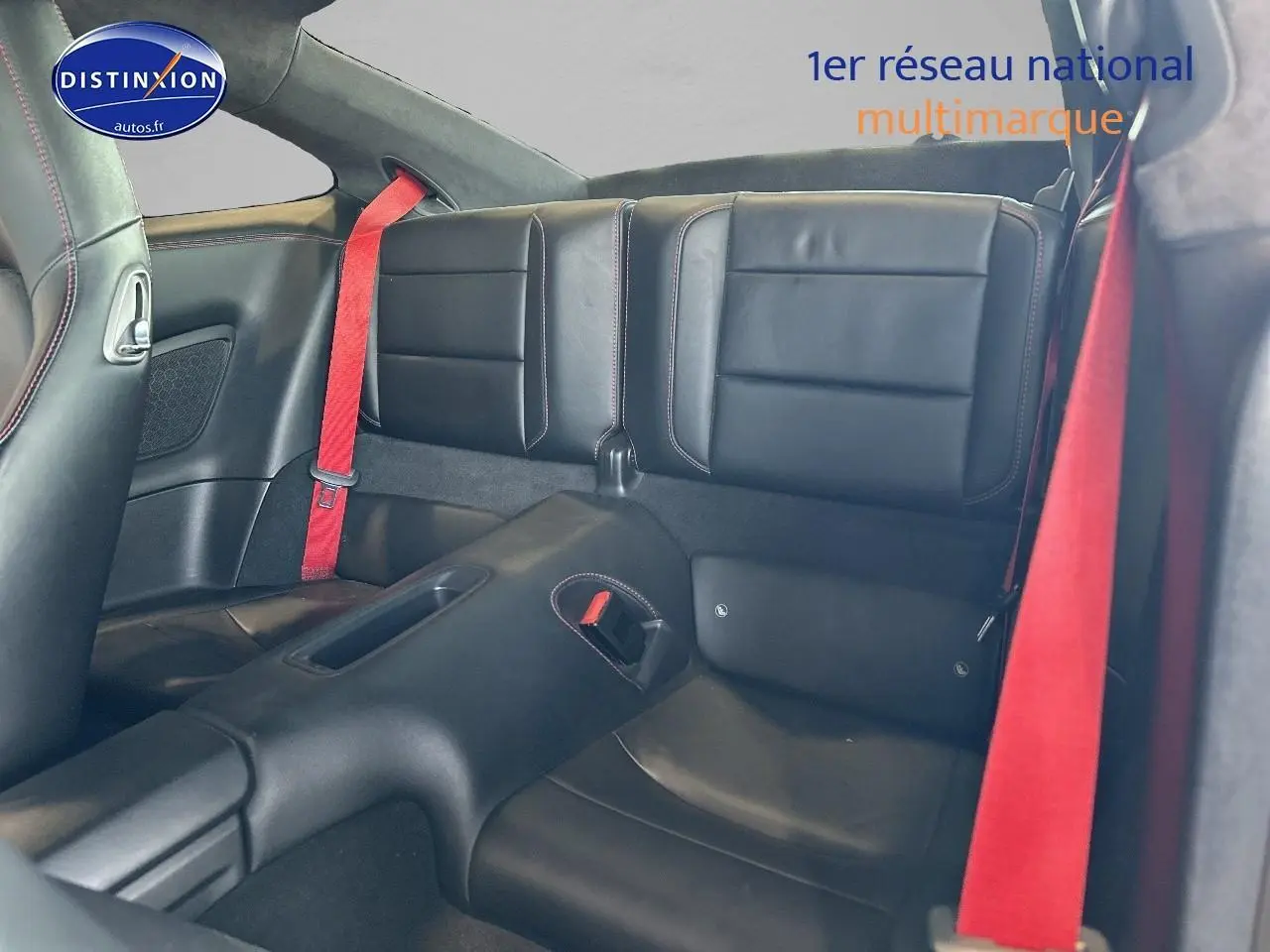 Banquette arrière en cuir noir avec ceintures rouges dans une Porsche 911 (991) Carrera 4 PDK vue de l'intérieur côté droit.