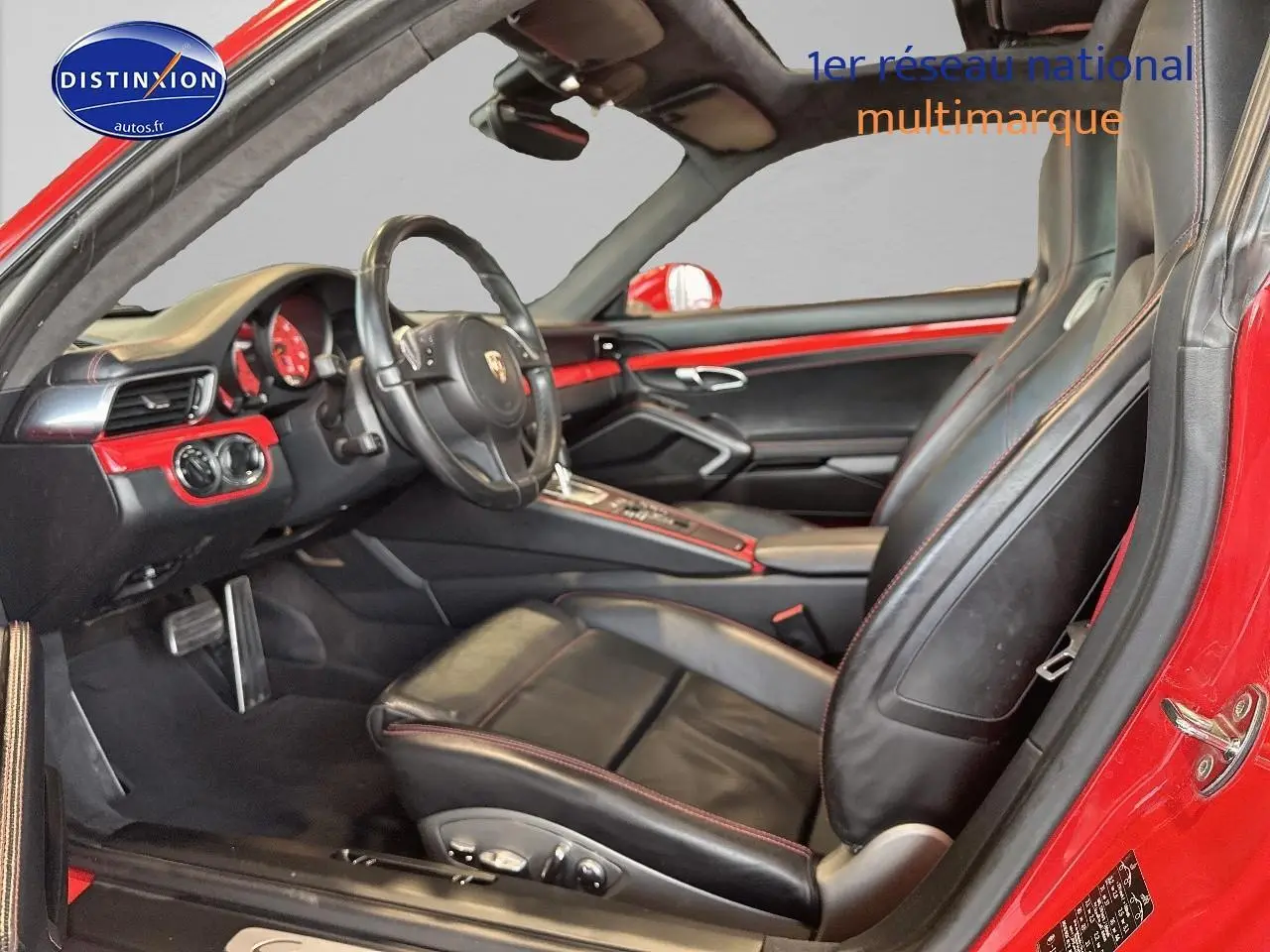 Intérieur noir et rouge de la Porsche 911 (991) Carrera 4 PDK vu côté conducteur avec volant cuir multifonction.