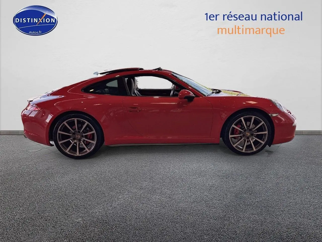 Profil latéral droit d'une Porsche 911 (991) Carrera 4 PDK rouge avec jantes alu et toit ouvrant électrique visible
