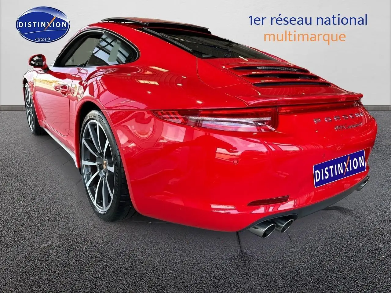 Vue 3/4 arrière droite d'une Porsche 911 Carrera 4 rouge avec échappement sport et jantes alu.