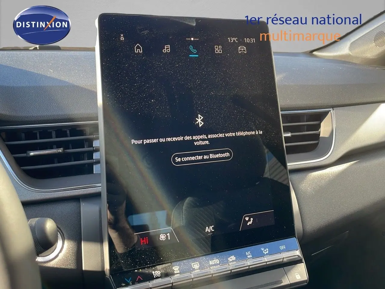 Vue intérieure du tableau de bord du Renault Captur 2025 avec écran tactile central et commandes climatisation visibles.
