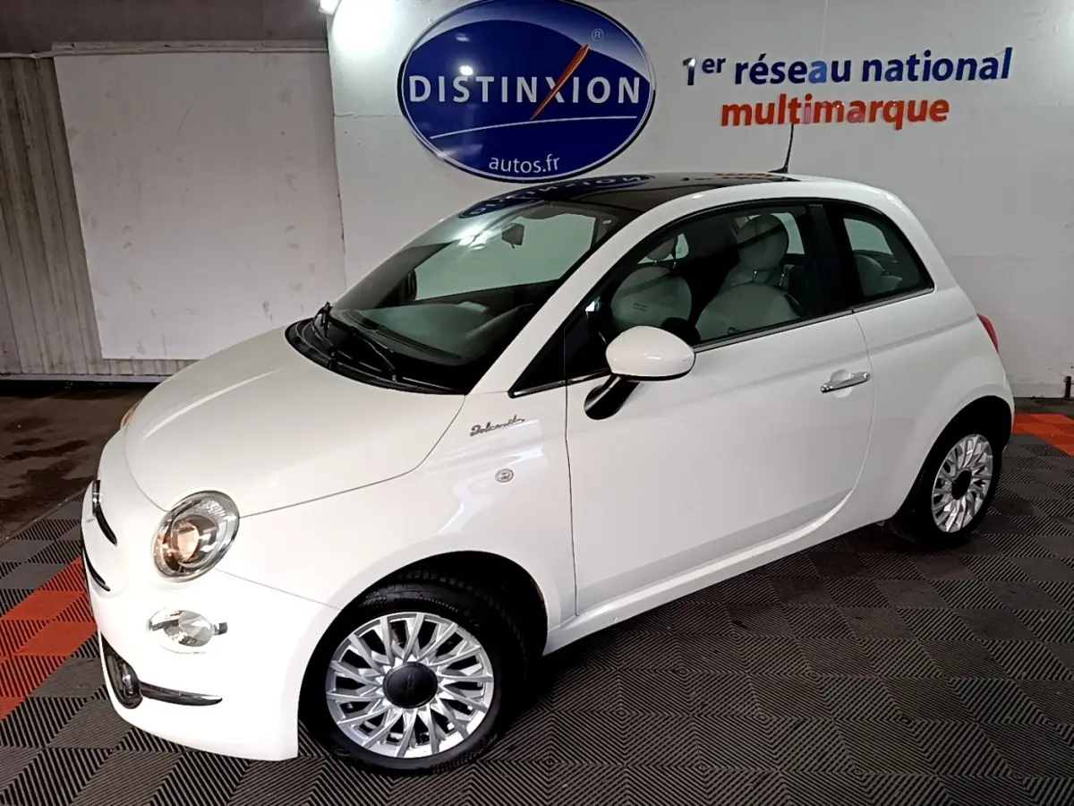 Vue 3/4 avant droite d'une FIAT 500 Dolcevita blanche avec jantes argentées et toit noir brillant.