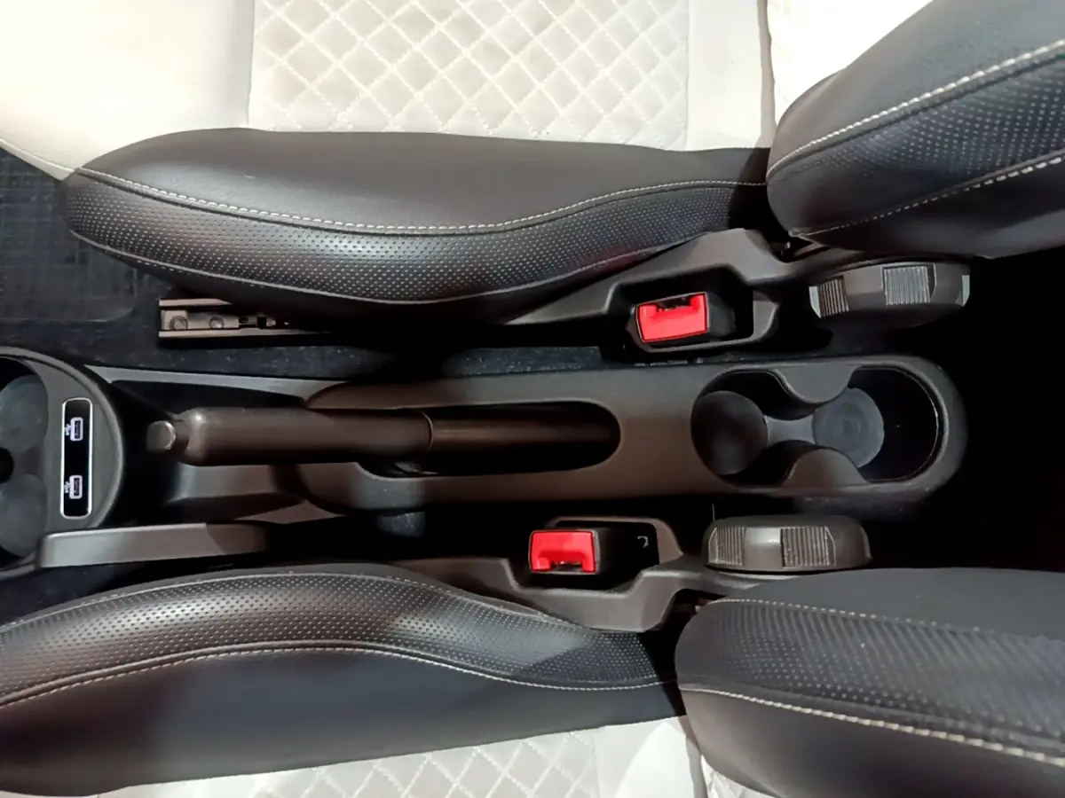 Vue plongeante sur la console centrale noire de la Fiat 500 Hybrid 2021 avec sièges cuir noir et blanc et frein à main manuel.