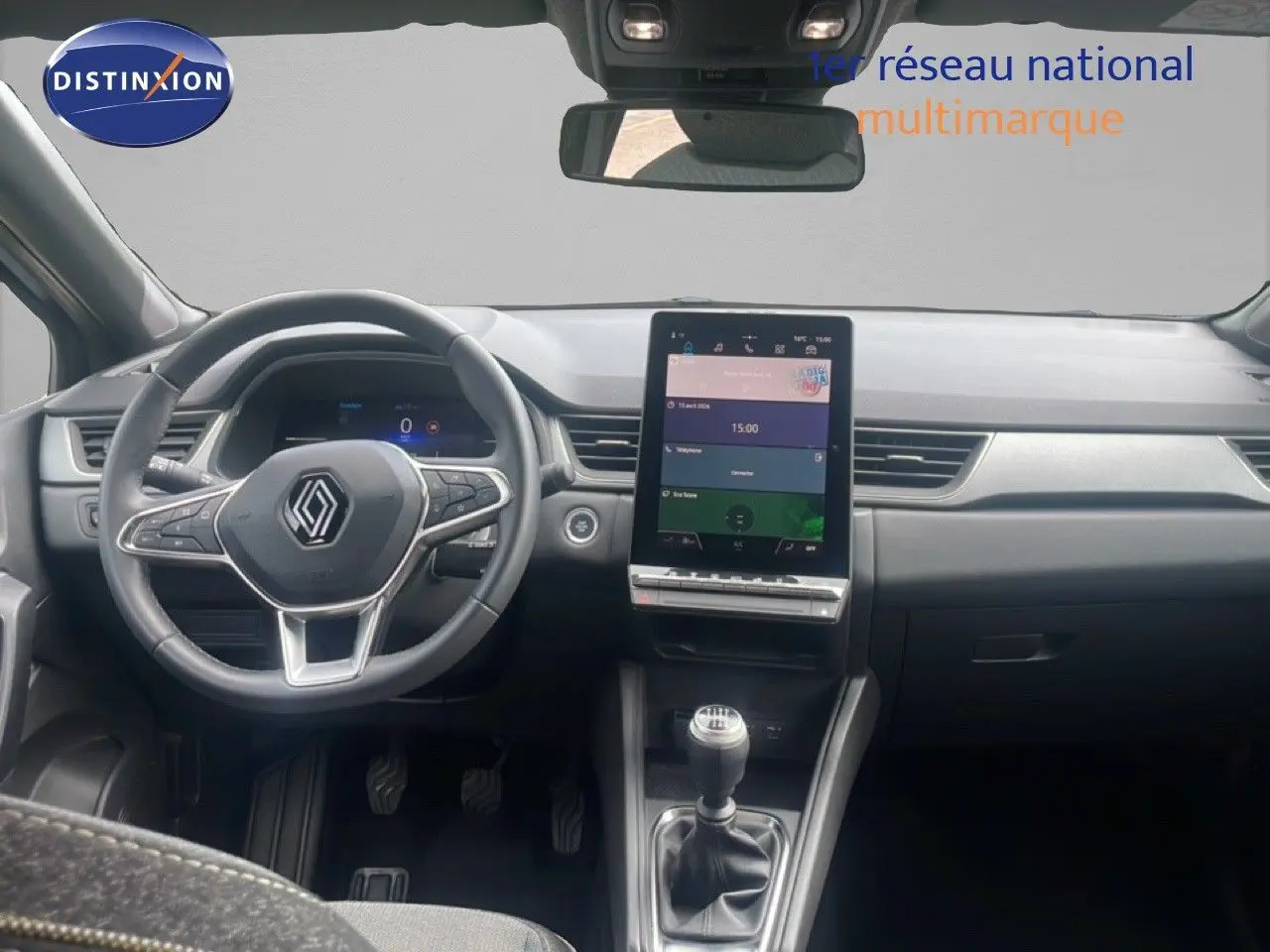 Vue intérieure avant du Renault Captur 2025, tableau de bord moderne avec écran tactile vertical et levier de vitesse manuel.