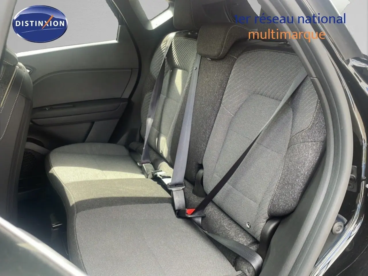 Vue intérieure arrière côté droit montrant les sièges tissu gris du Renault Captur noir étoile métal 2025.