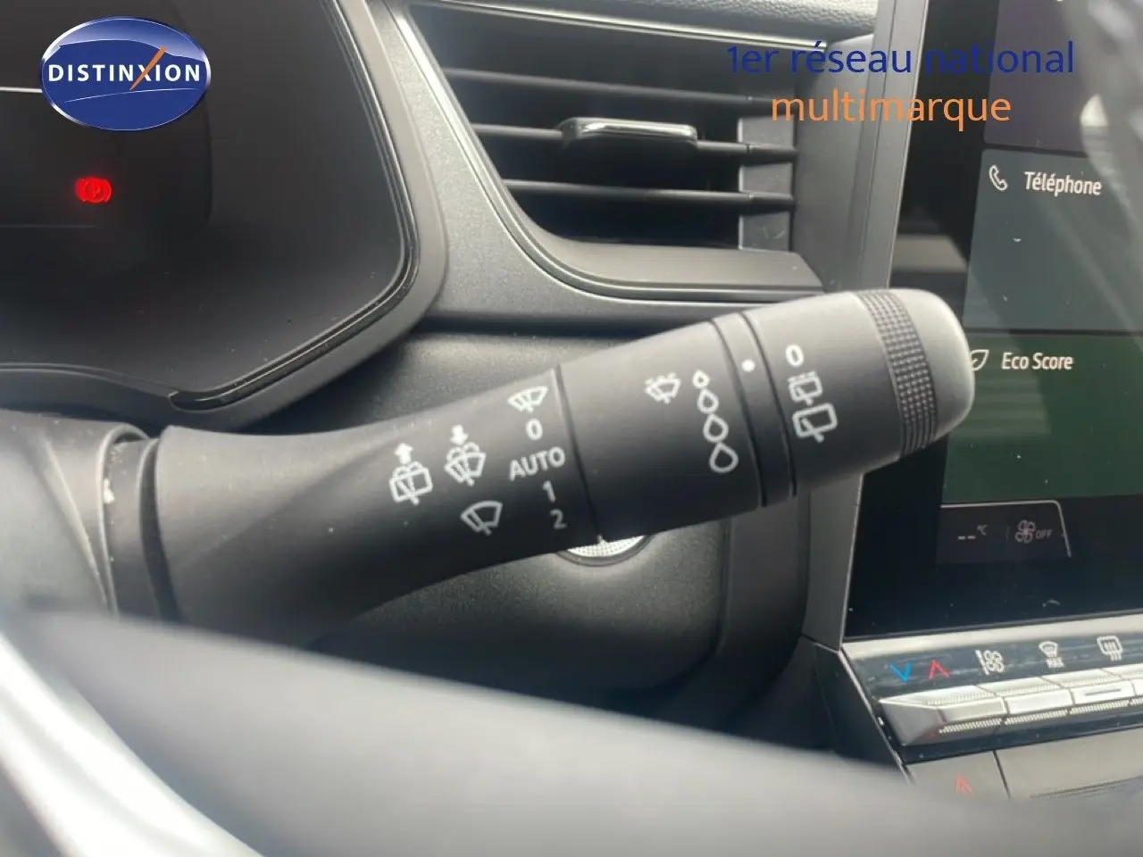 Gros plan sur la commande d’essuie-glace à gauche du volant dans l’habitacle du Renault Captur noir étoile métal avec toit gris.