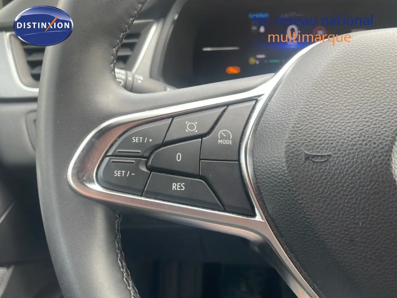 Gros plan sur les commandes au volant côté gauche du Renault Captur noir étoile métal avec toit gris, version 2025.