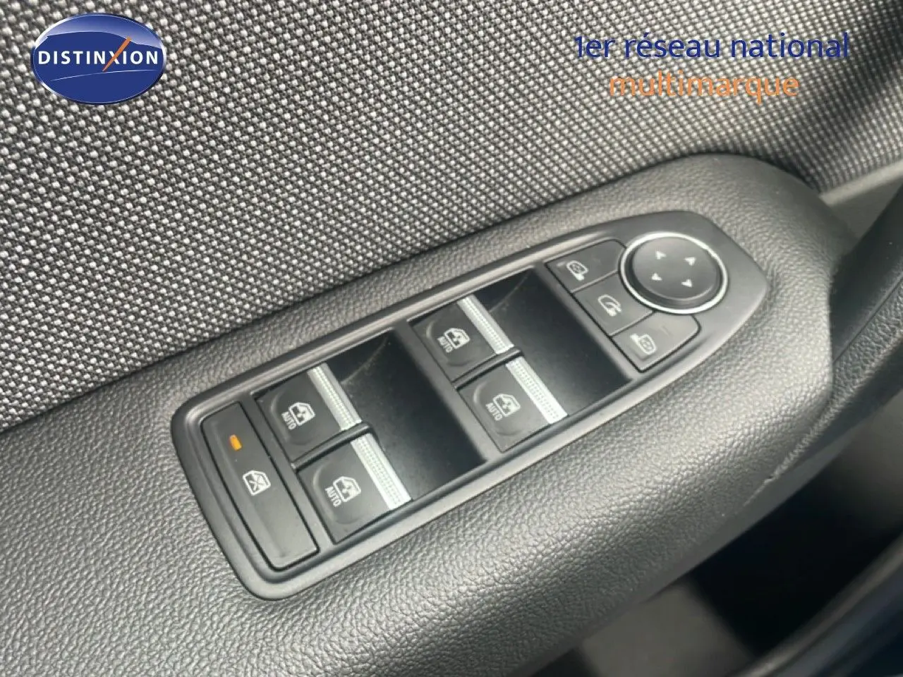 Gros plan sur les commandes des vitres électriques et rétroviseurs côté conducteur du Renault Captur noir étoile métal toit gris.