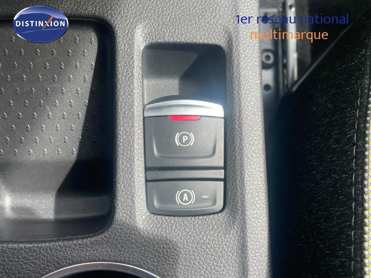 Gros plan sur les commandes de frein à main électronique et arrêt automatique du Renault Captur noir étoile métal avec toit gris.