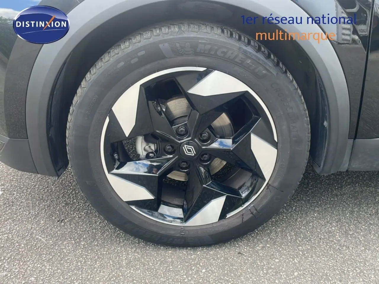 Gros plan sur la roue avant droite du Renault Captur noir étoile métal avec jante bi-ton gris et noir.