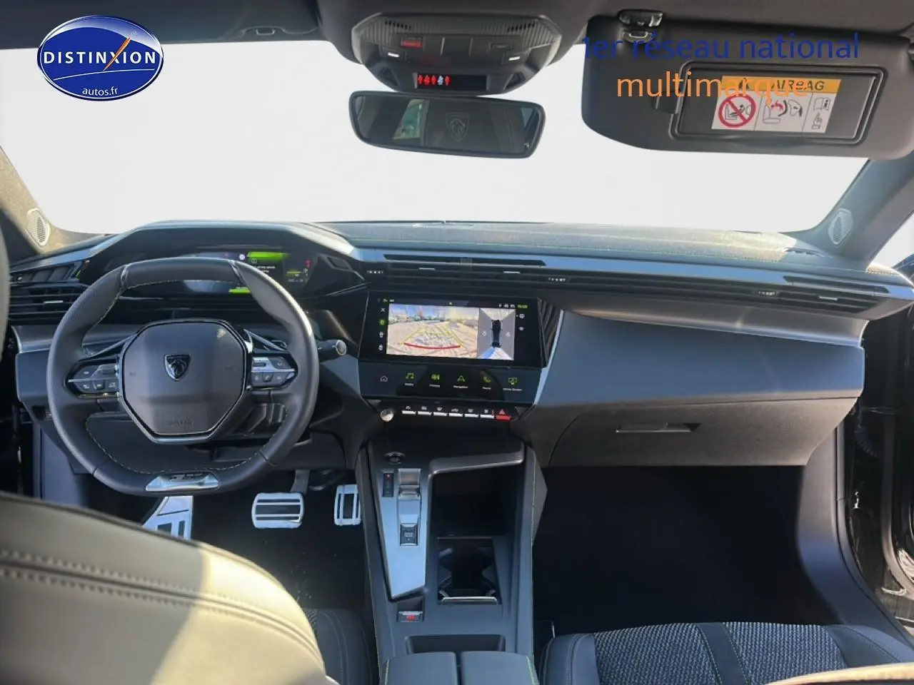 Intérieur Peugeot 408 Hybrid 2025 vu de face, tableau de bord noir avec écran tactile et volant cuir multifonctions.
