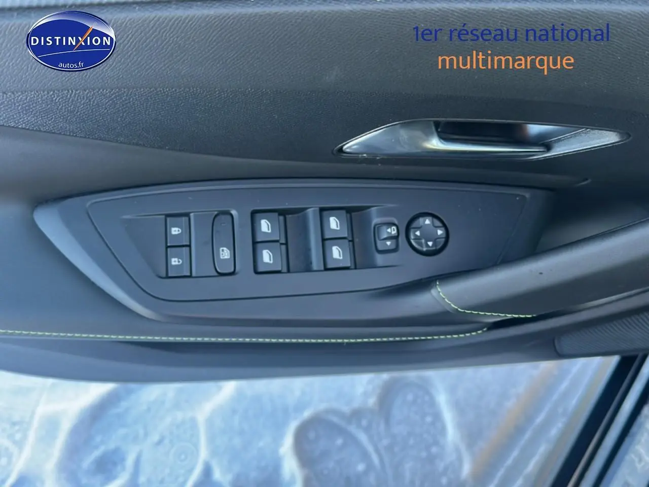 Commande des vitres et rétroviseurs sur la porte avant gauche d’une Peugeot 408 Hybrid 145 GT noir, intérieur noir avec surpiqûres vertes.