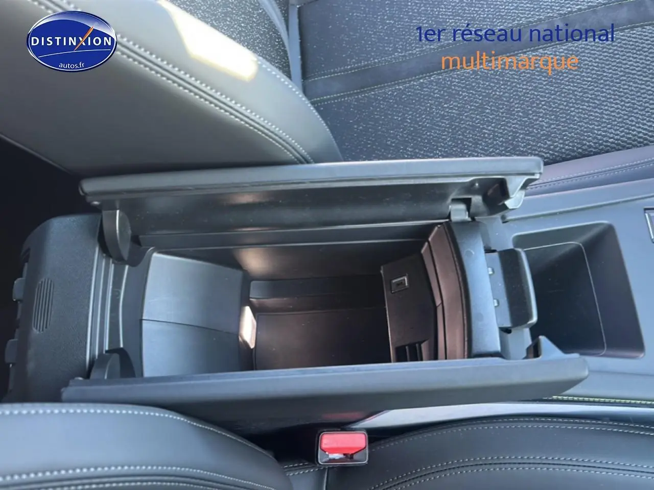 Vue plongeante sur l'accoudoir central ouvert en cuir noir du Peugeot 408 Hybrid 145 GT e-dcs6 2025.