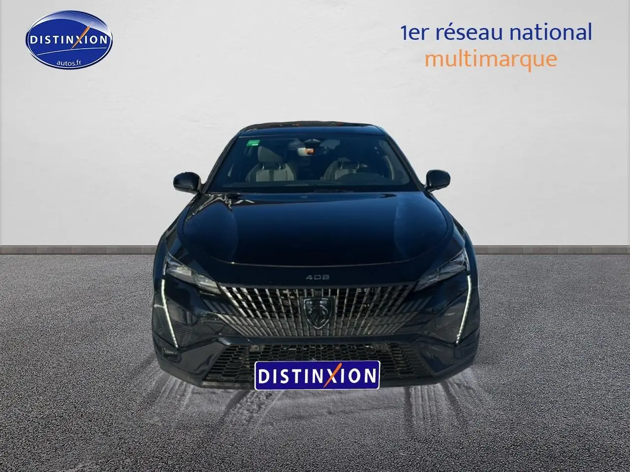 Vue frontale d'une Peugeot 408 Hybrid 145 GT e-dcs6 noire avec calandre distinctive et feux LED verticaux allumés.