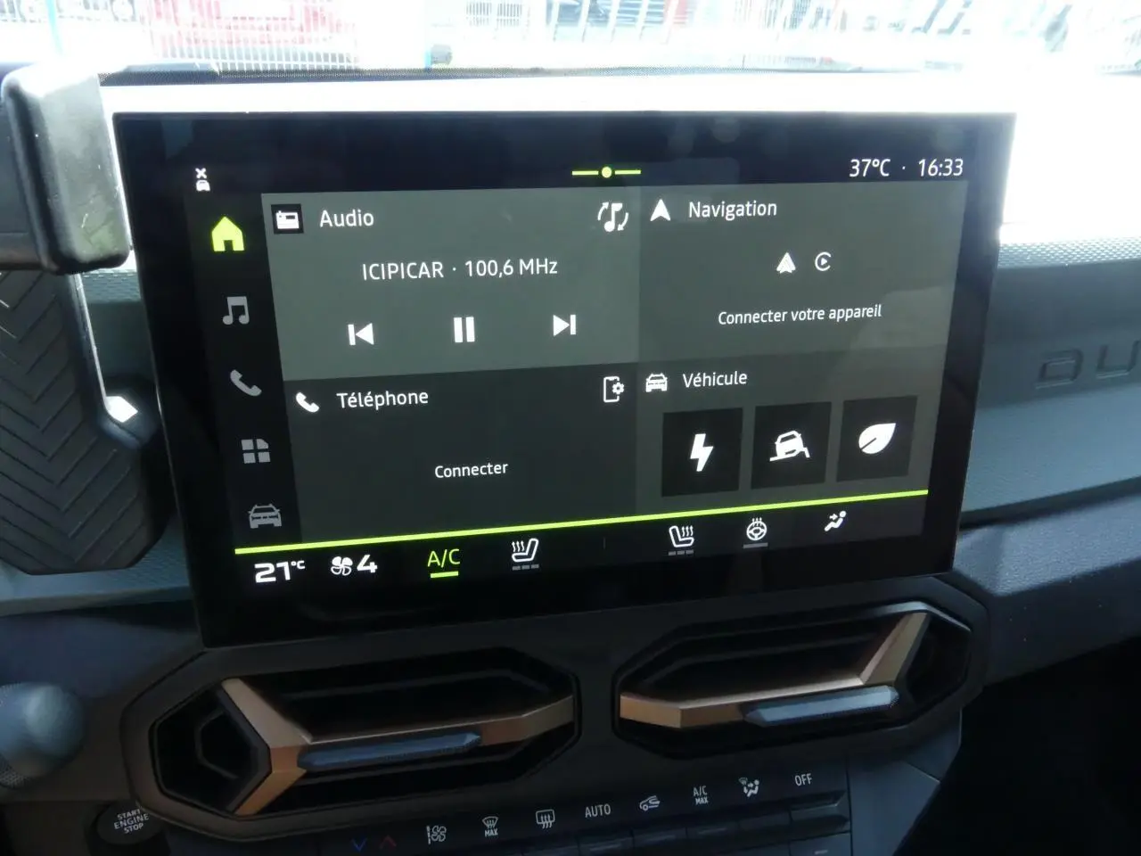 Écran tactile 10 pouces du tableau de bord du Dacia Duster blanc avec aérateurs brun cuivré visibles en partie basse.