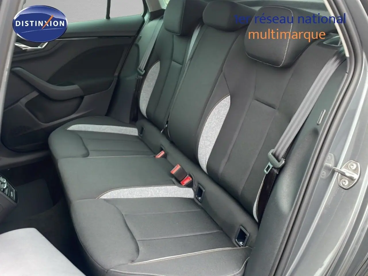 Vue côté droit de la banquette arrière gris noir du Skoda Kamiq 2025 avec détails tissu clair et ceinture de sécurité.